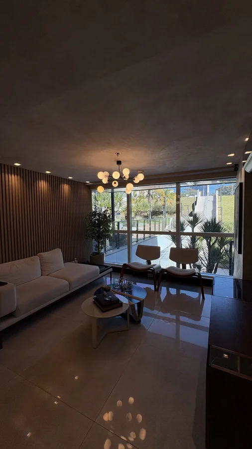 Recepção do Instituto com poltronas, plantas e vista para o jardim